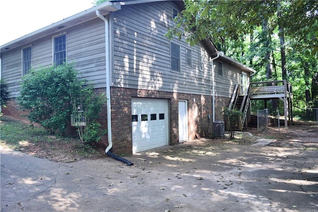 157 Sequoyah Cir, Canton, GA 30115 - view of property exterior featuring an attached garage, brick siding, driveway, stairs, and a wooden deck