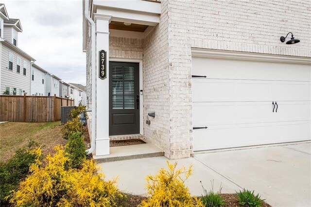 3739 Silvery Way, Powder Springs, GA 30127 - entrance to property with brick siding, central AC unit, fence, and a garage
