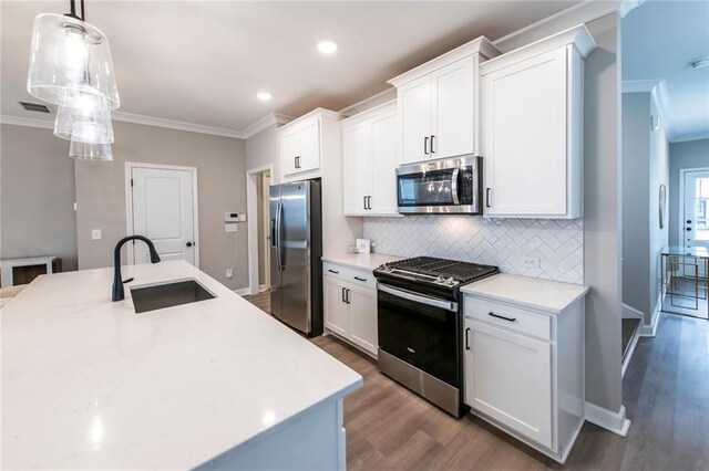 3739 Silvery Way, Powder Springs, GA 30127 - kitchen featuring tasteful backsplash, ornamental molding, appliances with stainless steel finishes, wood finished floors, and a sink