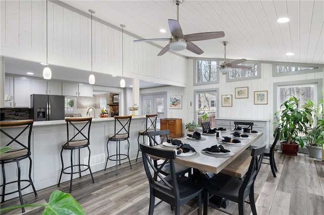 dining space featuring lofted ceiling, wooden ceiling, and light wood-style flooring