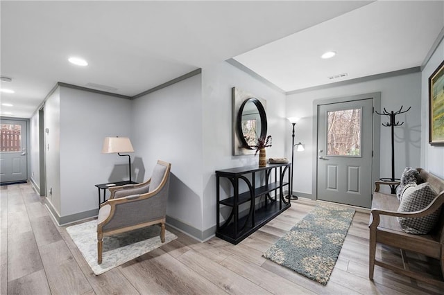 entryway with crown molding, baseboards, and wood finished floors