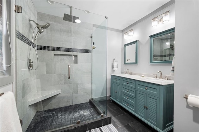 bathroom with double vanity, a shower stall, and a sink