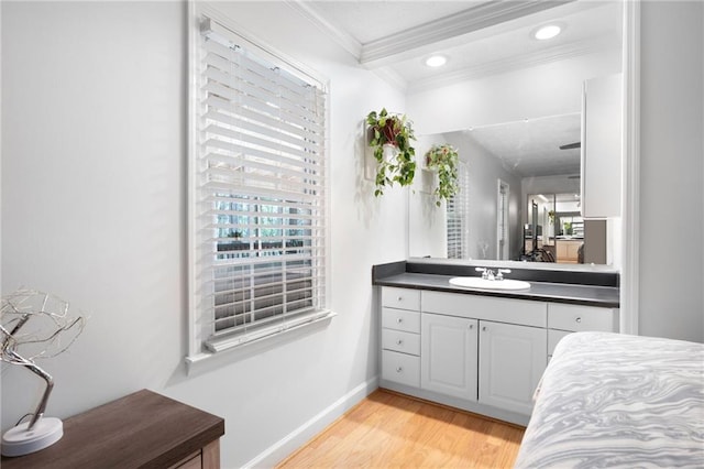 bathroom with recessed lighting, wood finished floors, vanity, baseboards, and crown molding