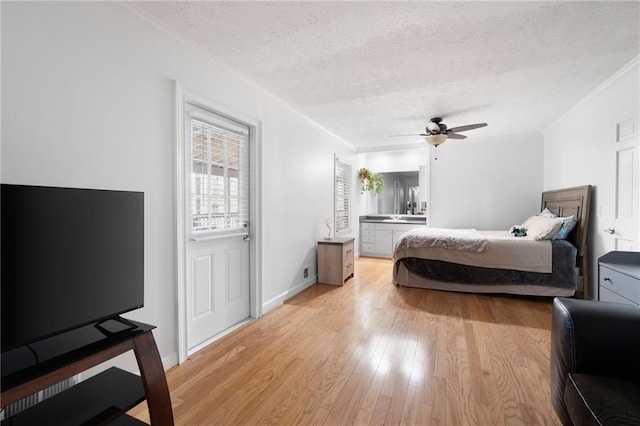 bedroom featuring a textured ceiling, ceiling fan, light wood-style flooring, baseboards, and crown molding