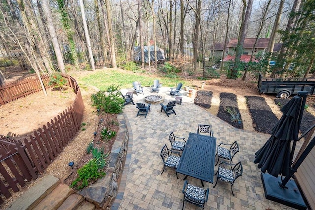 view of patio / terrace featuring an outdoor fire pit, outdoor dining space, and fence