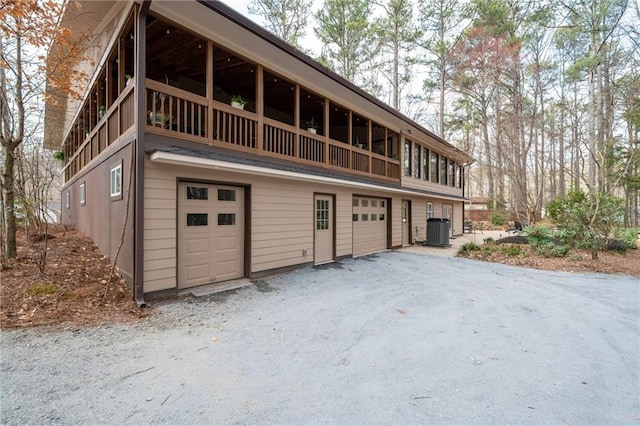 exterior space with a garage, driveway, and central AC unit