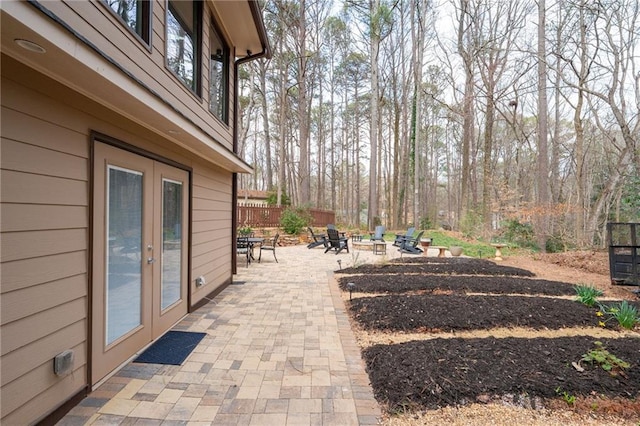 view of yard with french doors, a patio, a fire pit, and fence