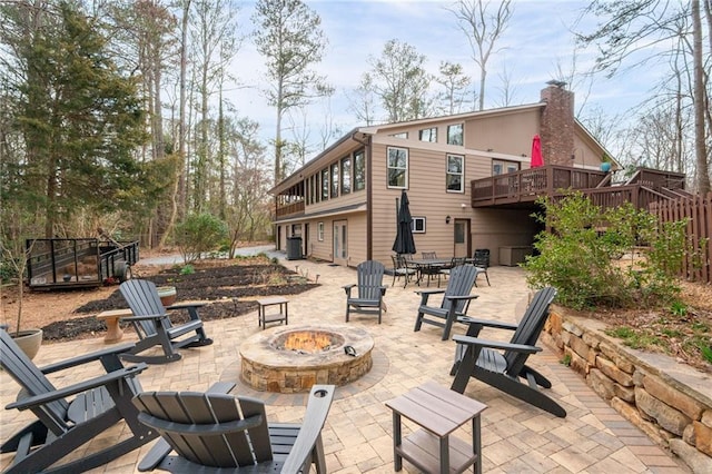 view of patio with an outdoor fire pit, a deck, and central air condition unit