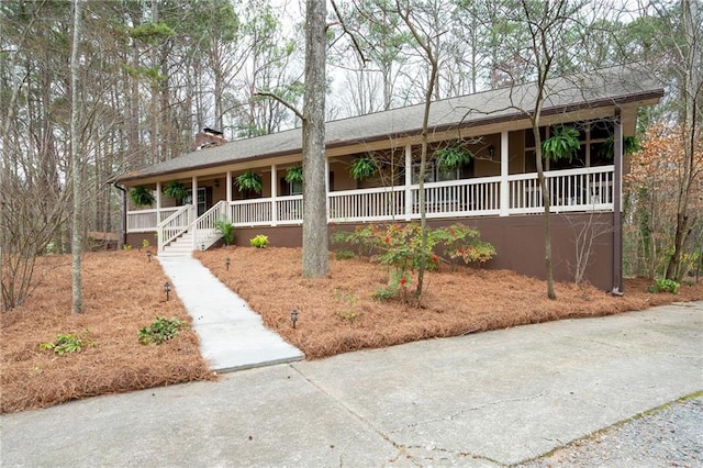 single story home with a chimney and a porch