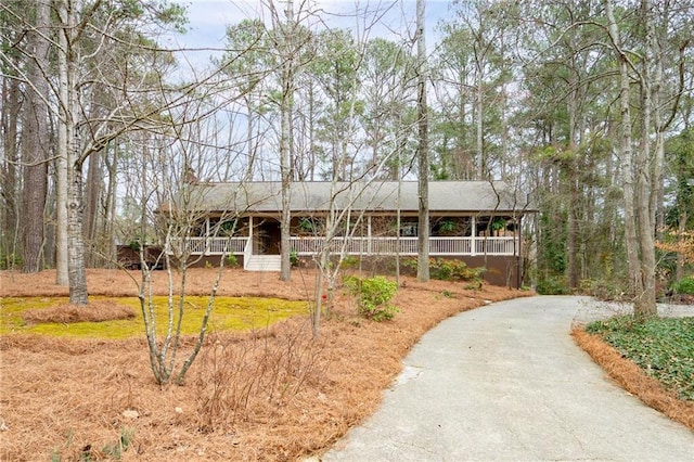 ranch-style house featuring aphalt driveway and covered porch