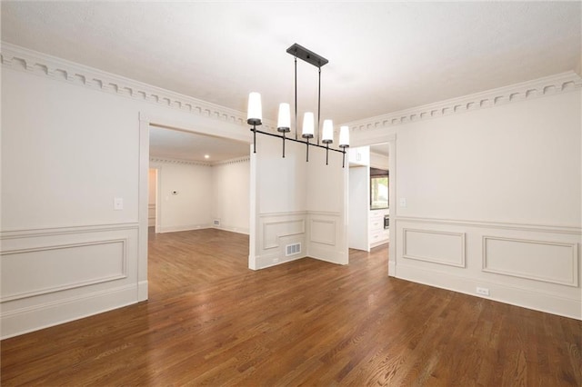 6141 Windsong Way, Smoke Rise, GA 30087 - unfurnished dining area featuring dark wood-style floors, ornamental molding, wainscoting, a decorative wall, and a chandelier