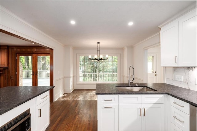 6141 Windsong Way, Smoke Rise, GA 30087 - kitchen with a sink, built in microwave, a peninsula, a chandelier, and white cabinetry
