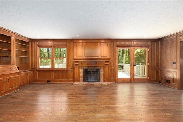 6141 Windsong Way, Smoke Rise, GA 30087 - unfurnished living room featuring wood finished floors, plenty of natural light, a textured ceiling, a fireplace, and wood walls