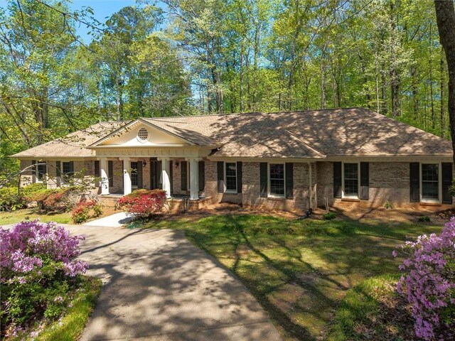 6141 Windsong Way, Smoke Rise, GA 30087 - neoclassical home with covered porch, brick siding, and a front yard
