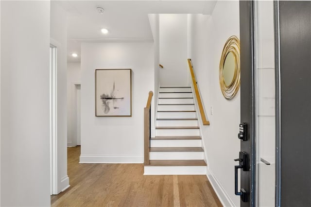 staircase with baseboards, wood finished floors, and recessed lighting