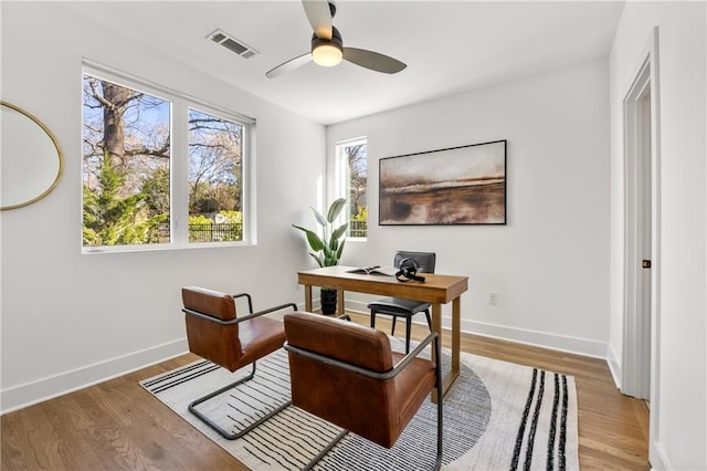 home office with ceiling fan, baseboards, visible vents, and light wood-style floors