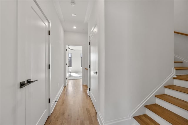 hallway featuring stairs, recessed lighting, light wood-type flooring, and baseboards