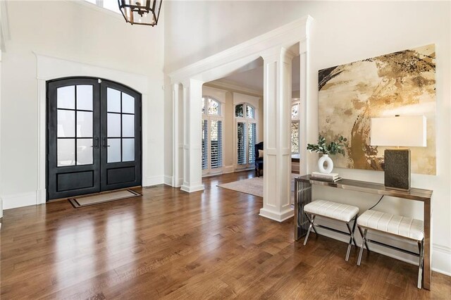 sitting room featuring decorative columns, wood finished floors, visible vents, and ornamental molding