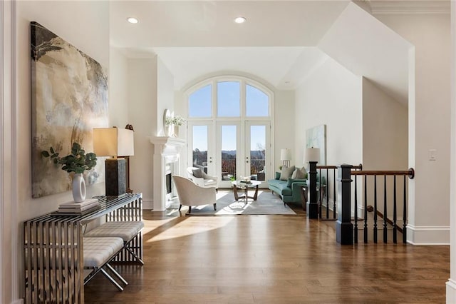 sitting room featuring crown molding, french doors, dark wood-type flooring, and a high ceiling