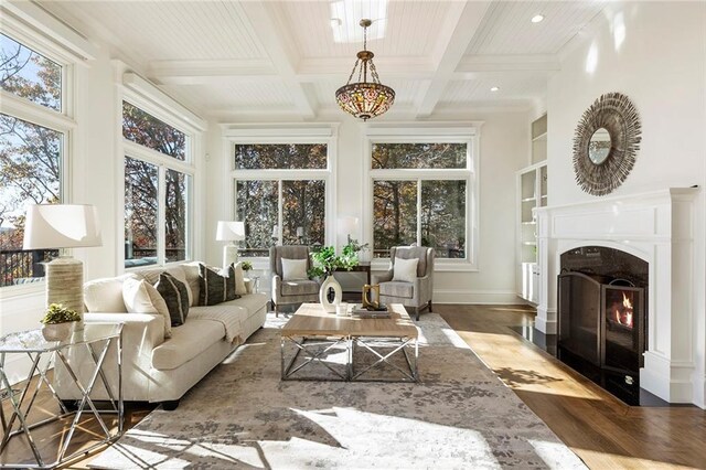 living room featuring a high end fireplace, built in shelves, beam ceiling, wood finished floors, and coffered ceiling