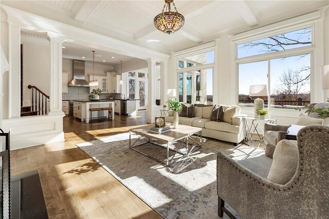 kitchen featuring appliances with stainless steel finishes, a center island, crown molding, and wall chimney range hood