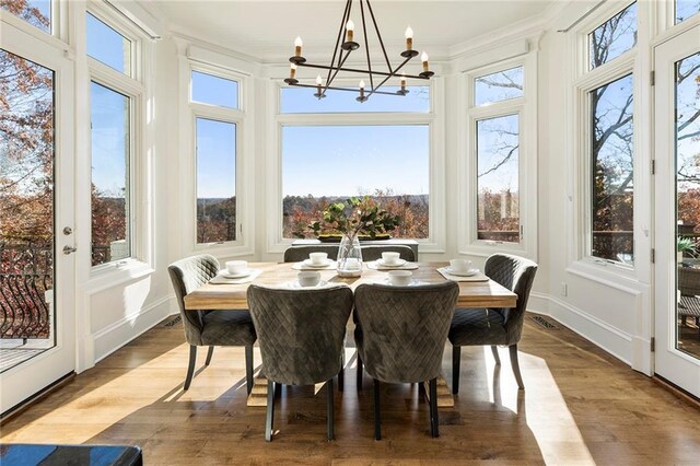 sunroom / solarium with a notable chandelier and visible vents