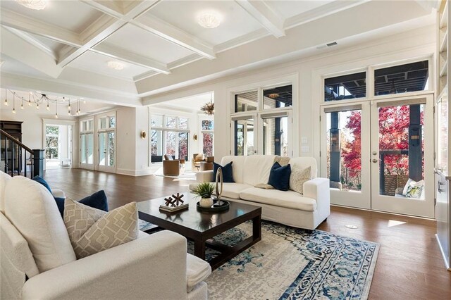 sunroom / solarium with a healthy amount of sunlight, a tray ceiling, and an inviting chandelier