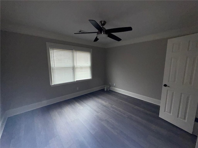 spare room featuring ceiling fan, baseboards, crown molding, and dark wood-type flooring