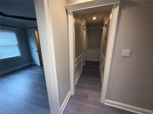 hallway with dark wood finished floors and a decorative wall