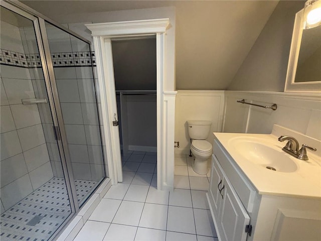 full bath featuring tile patterned flooring, a wainscoted wall, a shower stall, and vanity