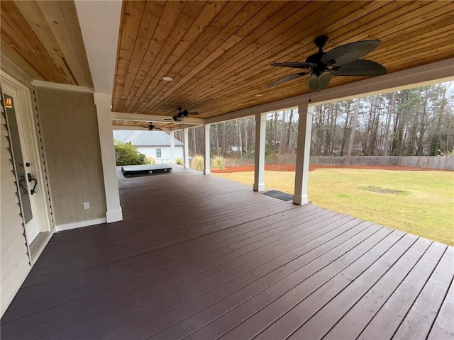 deck with a lawn, ceiling fan, and fence