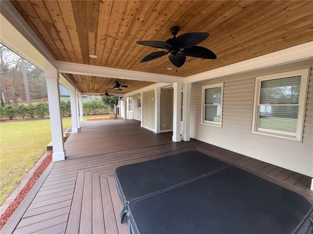 wooden deck with a yard and a ceiling fan