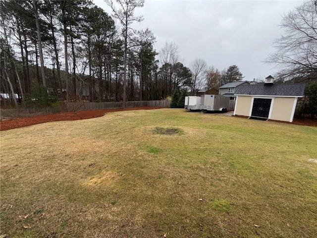 view of yard featuring an outdoor structure and fence