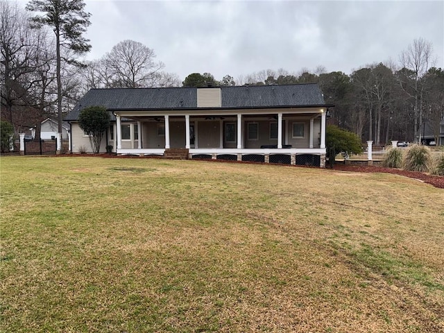 view of front of house featuring a porch, a chimney, a front yard, and fence