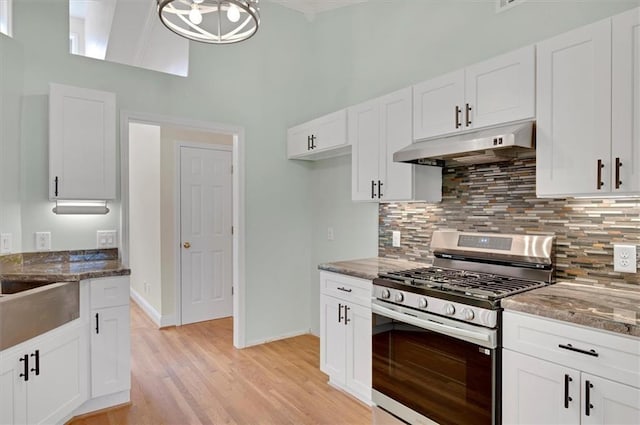 5410 Lenox Park Pl, Buford, GA 30518 - kitchen with stainless steel gas range, under cabinet range hood, a towering ceiling, tasteful backsplash, and white cabinets