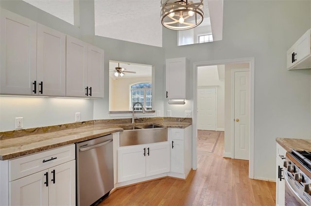 5410 Lenox Park Pl, Buford, GA 30518 - kitchen featuring appliances with stainless steel finishes, a sink, high vaulted ceiling, white cabinets, and light stone counters