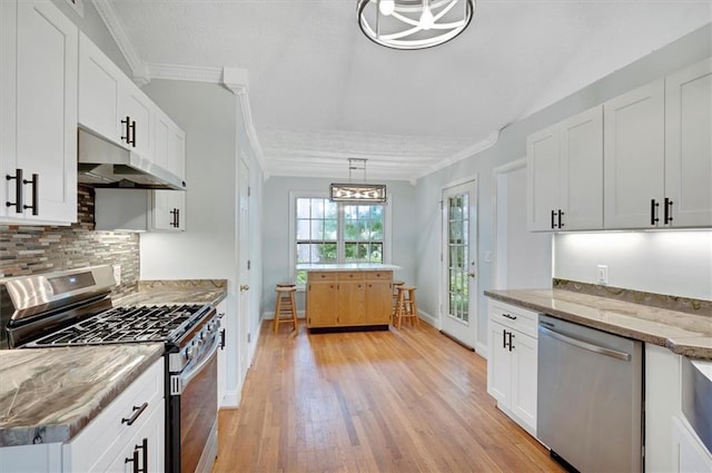 5410 Lenox Park Pl, Buford, GA 30518 - kitchen featuring appliances with stainless steel finishes, under cabinet range hood, decorative backsplash, light wood-style flooring, and baseboards