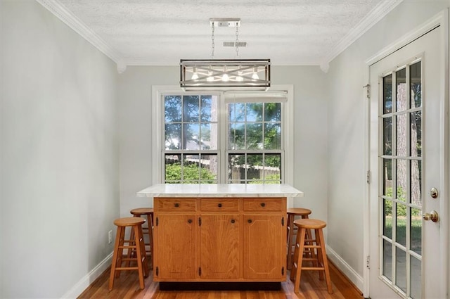 5410 Lenox Park Pl, Buford, GA 30518 - dining area featuring a dry bar, light wood-type flooring, baseboards, crown molding, and a textured ceiling