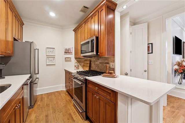 77 Peachtree Pl NE Unit 101, Atlanta, GA 30309 - kitchen featuring appliances with stainless steel finishes, backsplash, crown molding, brown cabinets, and light wood finished floors