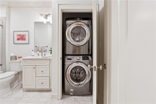 77 Peachtree Pl NE Unit 101, Atlanta, GA 30309 - laundry room featuring estacked washer and dryer, light marble finish floors, and ornamental molding