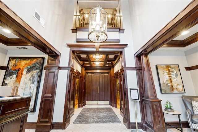 77 Peachtree Pl NE Unit 101, Atlanta, GA 30309 - entryway with a chandelier, coffered ceiling, light tile patterned floors, crown molding, and beamed ceiling