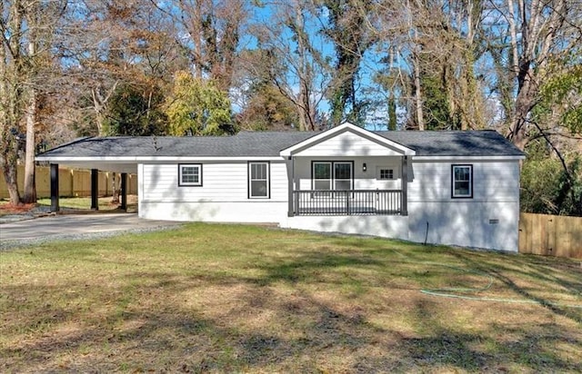 back of property featuring covered porch, a carport, and a lawn