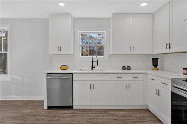 kitchen with stainless steel appliances, white cabinetry, sink, and plenty of natural light