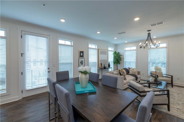 dining room featuring a healthy amount of sunlight, dark wood-style floors, and visible vents