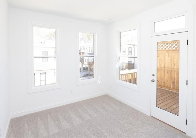 spare room with baseboards and carpet