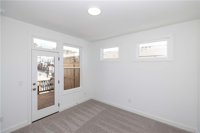 doorway to outside with carpet floors and baseboards