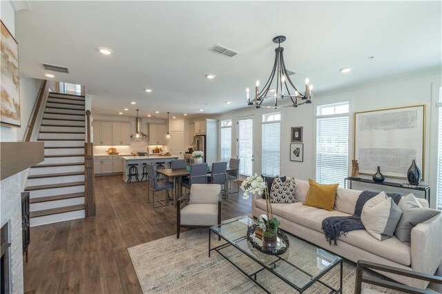 living room with dark wood-type flooring, recessed lighting, visible vents, and stairs