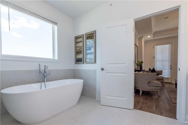 bathroom with a soaking tub and tile walls