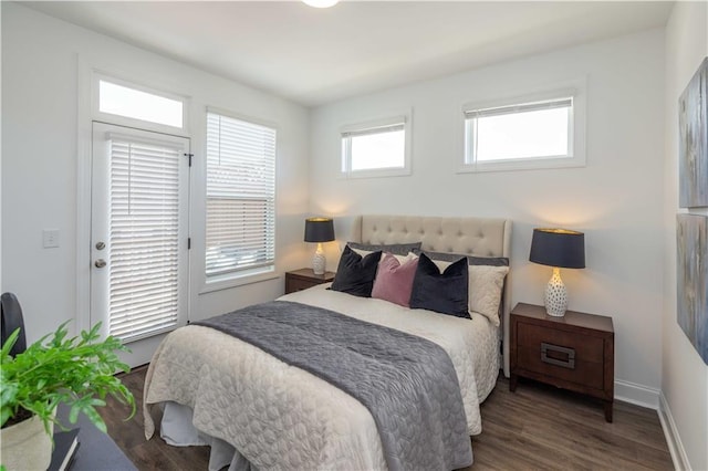 bedroom with access to outside, wood finished floors, and baseboards