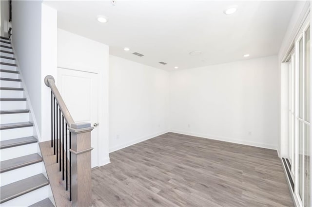 interior space with baseboards, recessed lighting, and wood finished floors